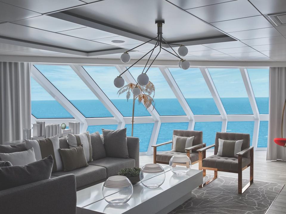 rendering of the living room with couches, chairs, and fancy ceiling lighting next to panoramic windows with views of the ocean in the Iconic suite aboard the Celebrity Apex cruise ship