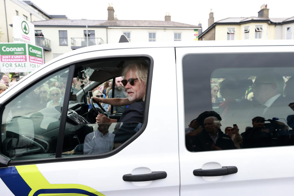 Musician Bob Geldof rides in a taxi as part of the funeral cortege for singer Sinead O'Connor as it passes through her former hometown of Bray, Co Wicklow, Ireland, Tuesday, Aug. 8, 2023. O’Connor’s family invited the public to line the waterfront in Bray on Tuesday as her funeral procession passes by. Fans left handwritten notes outside her former home, thanking her for sharing her voice and her music. (Liam McBurney/PA via AP)