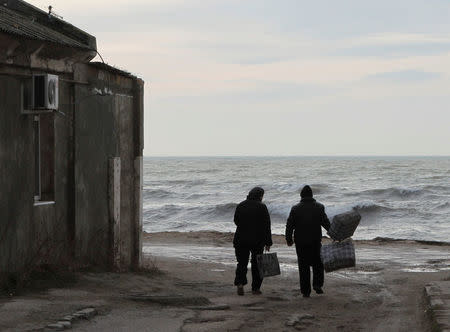 A couple walks towards the sea in the port city of Yevpatoriya, Crimea, February 3, 2016. Picture taken February 3, 2016. REUTERS/Pavel Rebrov