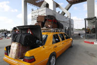 Passengers ride a car and wait at the gate to be check by Hamas security officers to cross the border to the Egyptian side of Rafah crossing, in Rafah, Gaza Strip, Tuesday, Aug. 11, 2020. Egypt reopened Rafah Crossing for three days starting Tuesday for humanitarian cases in and out of the Gaza Strip, including medical patients and people who had Egyptian and international citizenship. The border was closed since March. (AP Photo/Adel Hana)