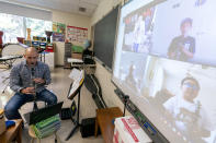 Erick DiVito demonstrates the clarinet as he teaches a remote music class during the coronavirus outbreak at the Osborn School, Tuesday, Oct. 6, 2020, in Rye, N.Y. (AP Photo/Mary Altaffer)