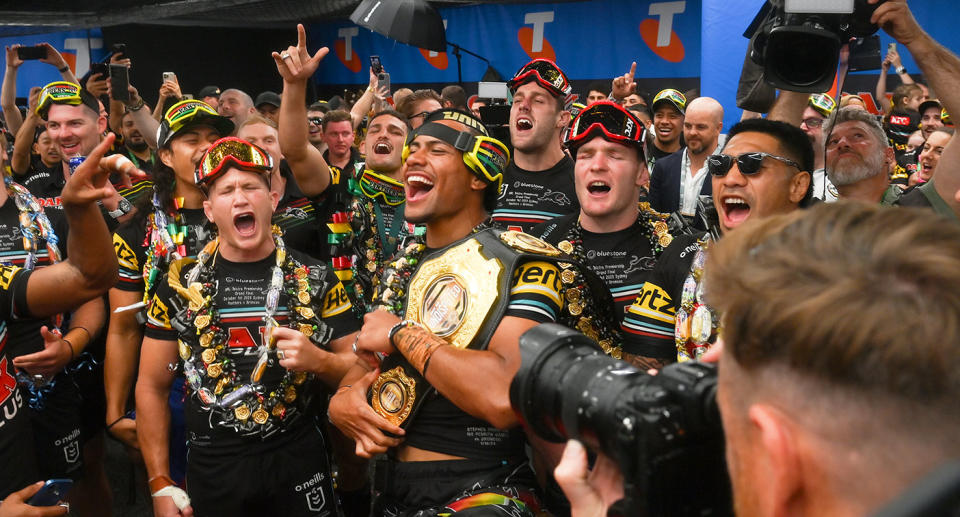 Pictured centre, Stephen Crichton celebrates after winning his third straight NRL premiership with Penrith.