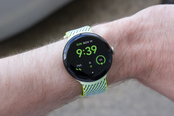 Someone wearing the Google Pixel Watch 2 with a yellow/green fabric band.