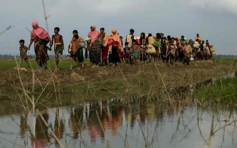 Displaced Rohingya refugees from Rakhine state in Myanmar carry their belongings as they flee violence, near Ukhia, near the border between Bangladesh and Myanmar on September 4 - Credit: K.M. ASAD/AFP