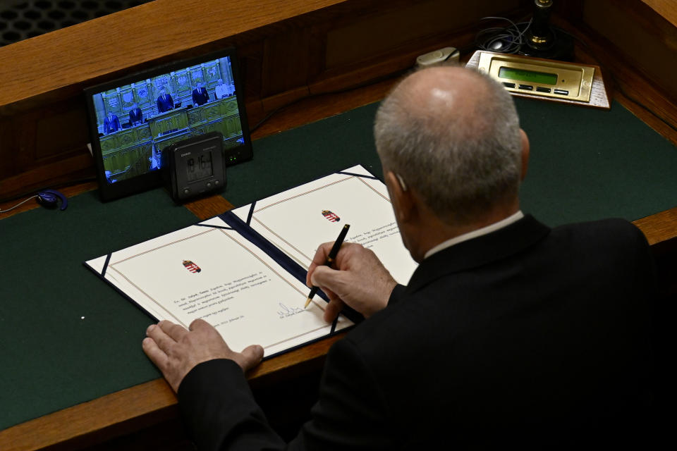 Tamas Sulyok, the former head of Hungary's Constitutional Court, signs the oath as the country's President after being voted in by lawmakers in a parliament session, in Budapest, Hungary, Monday, Feb 26, 2024. Hungary's former president, Katalin Novak, stepped down in February, over a pardon she issued to an accomplice in a child sexual abuse case.(AP Photo/Denes Erdos)