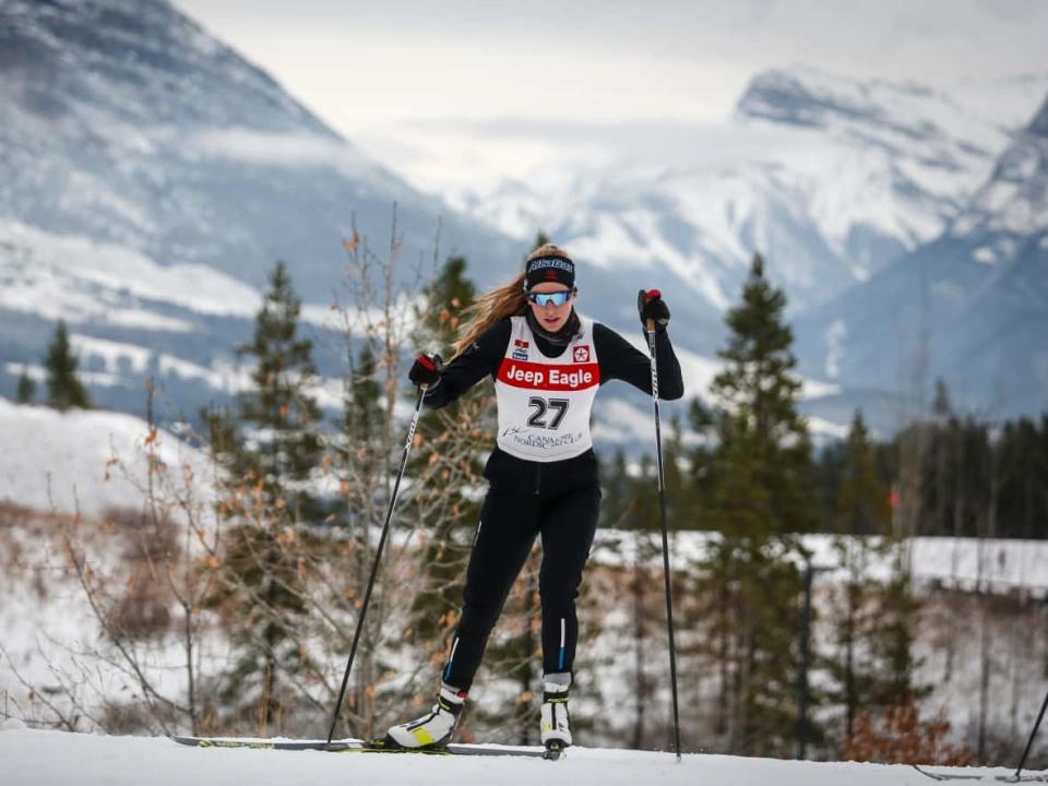 Whitehorse-born cross-country skier Dahria Beatty skis up a hill during training in Canmore, Alta. Beatty secured a spot on the Canadian Olympic team last weekend and will be heading to Beijing later this month. (Jeff McIntosh/The Canadian Press - image credit)