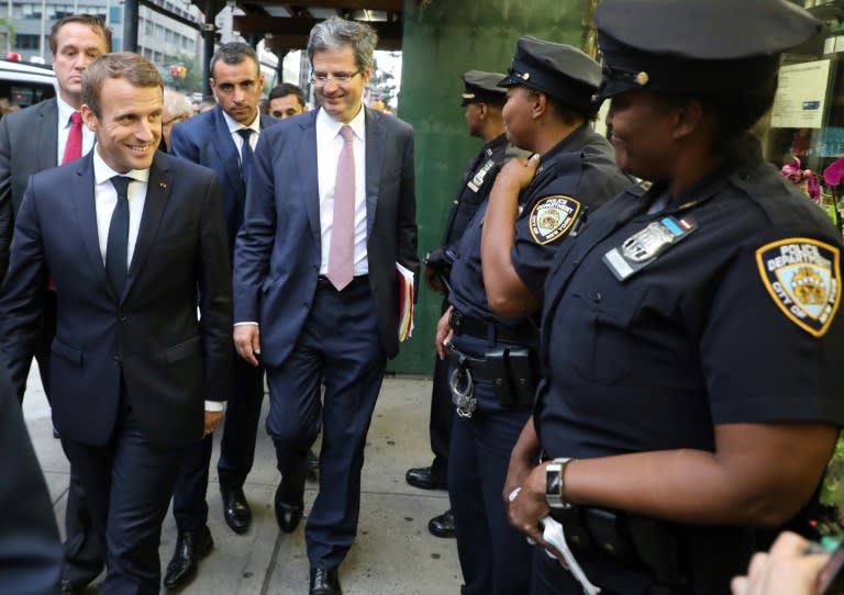 France's President Emmanuel Macron smiles at New York police officers as he walks down Second Avenue on his way to the French mission at the United Nations on Monday