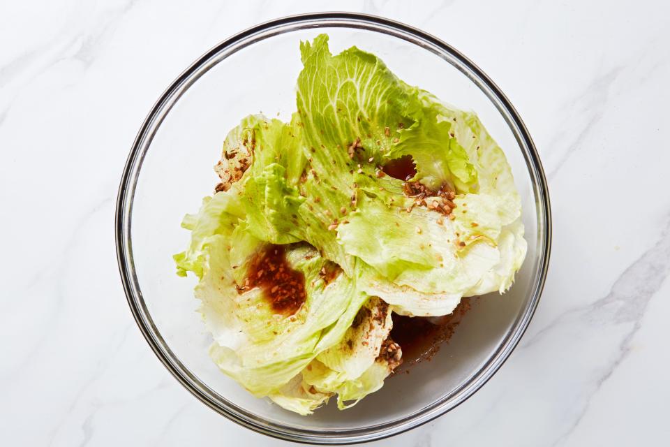 Layering the lettuce and brine ensures the leaves pickle evenly.