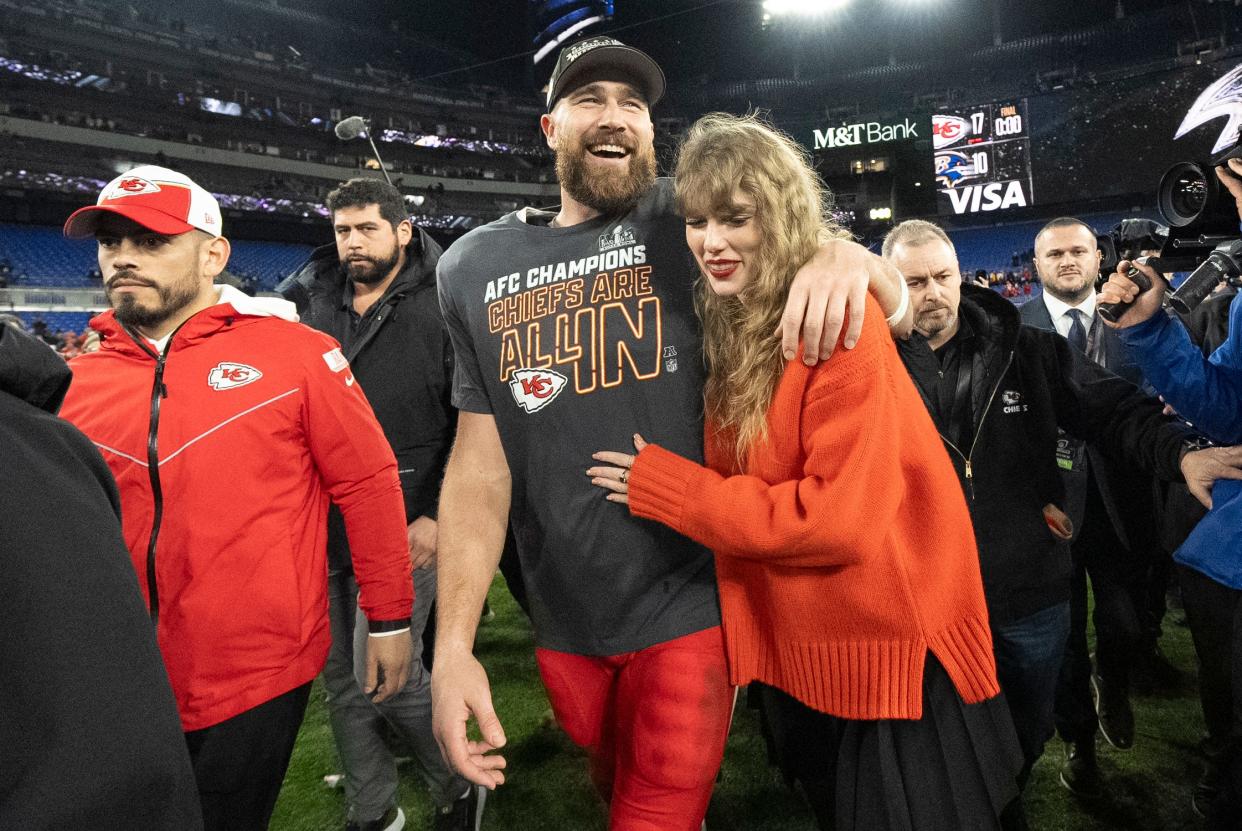 Travis Kelce and Taylor Swift walk on the field in Baltimore after the AFC championship game.