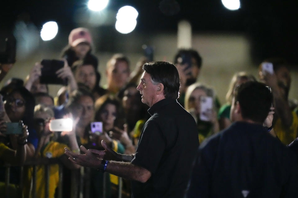 Brazilian President Jair Bolsonaro, who is running for another term, talks to followers after general election polls closed in Brasilia, Brazil, Sunday, Oct. 2, 2022. (AP Photo/Eraldo Peres)