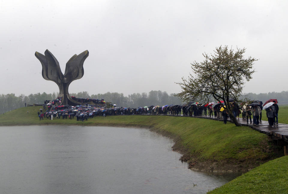 Hundreds gather at the memorial center to pay their respects for tens of thousands of people killed in death camps run by Croatia's pro-Nazi puppet state in WWII, in Jasenovac, Croatia, Friday, April 12, 2019. Croatia's Jewish, Serb, anti-fascist and Roma groups have commemorated the victims of a World War II death camp, snubbing the official ceremonies for the fourth year in a row over what they say is government inaction to curb neo-Nazi sentiments in the European Union country. (AP Photo/Nikola Solic)