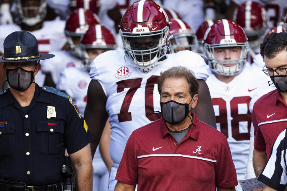 FILE - In this Sept. 26, 2020, file photo, Alabama coach Nick Saban leads his team to the field before an NCAA college football game against Missouri in Columbia, Mo. Saban and athletic director Greg Byrne have tested positive for COVID-19, four days before the Southeastern Conference's biggest regular-season showdown.  The second-ranked Crimson Tide is set to face No. 3 Georgia on Saturday, and may be without their iconic 68-year-old coach. (AP Photo/L.G. Patterson, File)