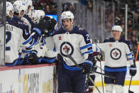 Winnipeg Jets center Sean Monahan, front right, is congratulated as he passes the team box after scoring in the first period of an NHL hockey game against the Colorado Avalanche, Saturday, April 13, 2024, in Denver. (AP Photo/David Zalubowski)