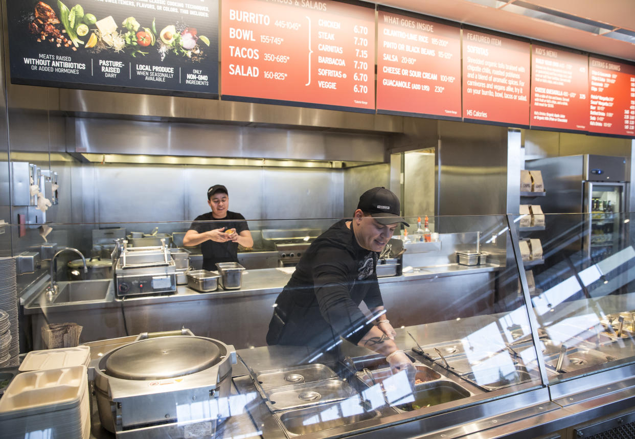 A Chipotle Mexican Grill employee prepares food on Tuesday Dec. 15, 2015, in Seattle. Chipotle founder and CEO Steve Ells was visiting restaurants in the Pacific to discuss new food safety protocols with employees after an E. coli outbreak sickened 50 people in the Northwest. (AP Photo/Stephen Brashear)