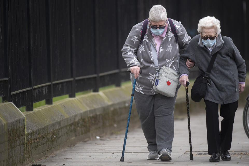 Two elderly women wearing protective face masks walk in Westminster, London as the UK continues in lockdown to help curb the spread of the coronavirus.