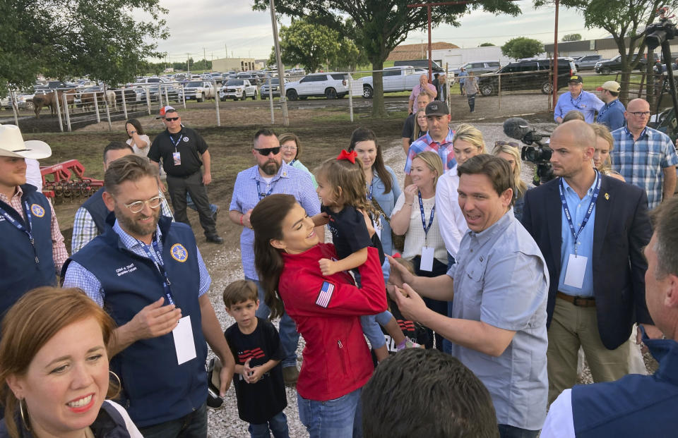 Republican presidential candidate Florida Gov. Ron DeSantis hands his daughter Mamie, 3, to wife, Casey, before greeting supporters, upon arriving at a rodeo in Ponca, Okla., Saturday, June 10, 2023. (AP Photo/Thomas Beaumont)