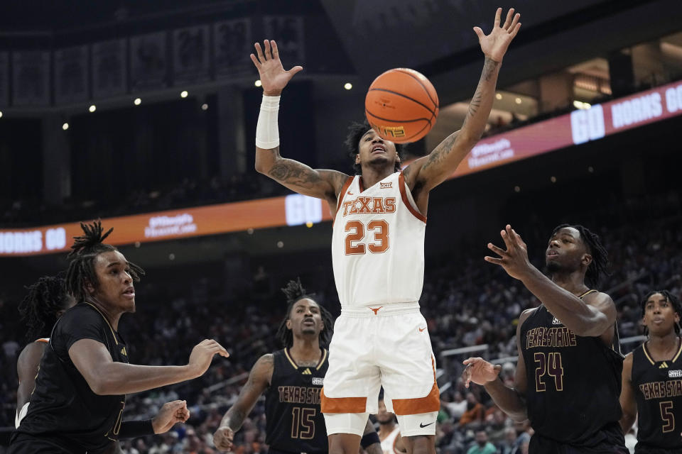 Texas forward Dillon Mitchell (23) loses control of the ball as he drives to the basket against Texas State forward Brandon Love (24) during the second half of an NCAA college basketball game in Austin, Texas, Thursday, Nov. 30, 2023. (AP Photo/Eric Gay)