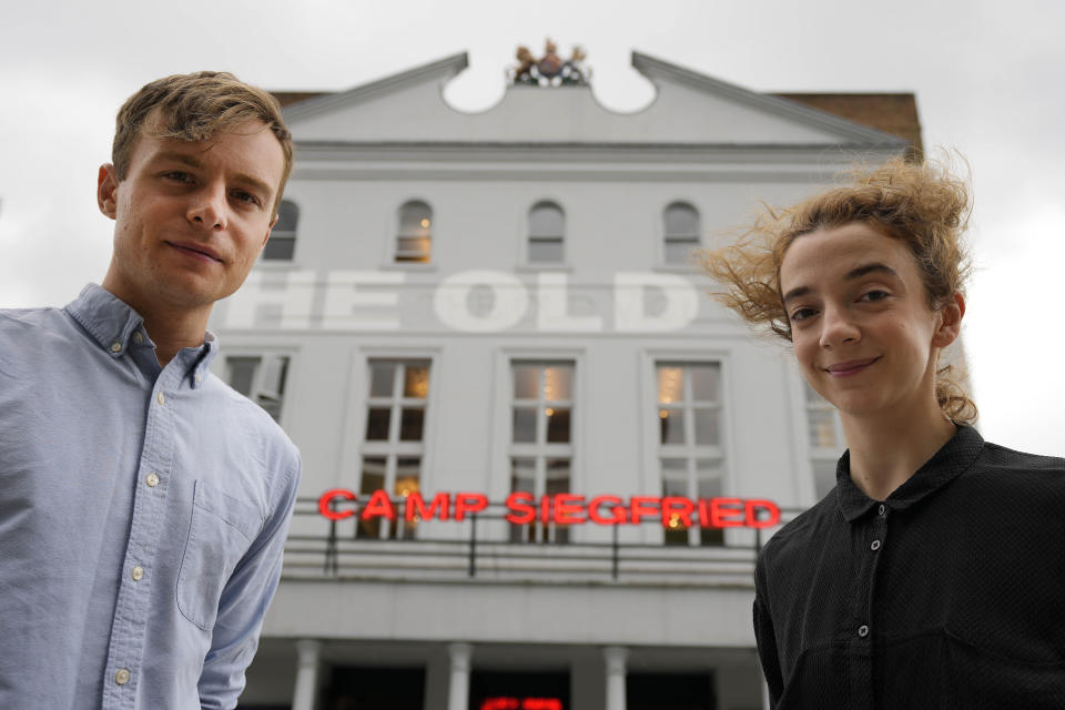 Actors Patsy Ferran, right and Luke Thallon, stars of the play Camp Siegfried, pose for a photographer in front of the Old Vic theatre in London, Friday, Sept. 10, 2021. London's Old Vic Theatre is reopening at full capacity for the first time since the pandemic began. The show is “Camp Siegfried,” American writer Bess Wohl's play about a summer camp for Nazis on New York's Long Island. It's based on a real-life camp in the 1930s that indoctrinated young German-Americans into the ideas of the Third Reich, and depicts two teenagers whose burgeoning relationship collides with the insidious ideology of Nazism. (AP Photo/Frank Augstein)