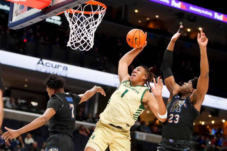 Charlotte's Dishon Jackson (1) dunks the ball as Memphis' Nae'Qwan Tomlin (7) and Malcolm Dandridge (23) guard him during the game between the University of Charlotte and the University of Memphis at FedExForum in Memphis, Tenn., on Wednesday, February 21, 2024.