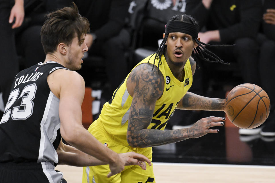 Utah Jazz's Jordan Clarkson, right, looks to pass as he is defended by San Antonio Spurs' Zach Collins during the second half of an NBA basketball game, Monday, Dec. 26, 2022, in San Antonio. (AP Photo/Darren Abate)