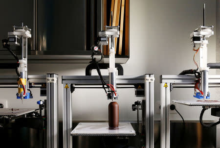 A specialized 3D printing machine applies melted chocolate to shape a chocolate beer bottle at Belgian chocolate company Miam Factory in Gembloux, Belgium, April 10, 2017. REUTERS/Francois Lenoir