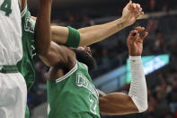 Boston Celtics forward Jayson Tatum, center, chips the tooth of guard Jaylen Brown, right, while reaching for a rebound against Milwaukee Bucks forward Giannis Antetokounmpo (34) during the first half of an NBA basketball game, Saturday, Dec. 25, 2021, in Milwaukee. (AP Photo/Jon Durr)