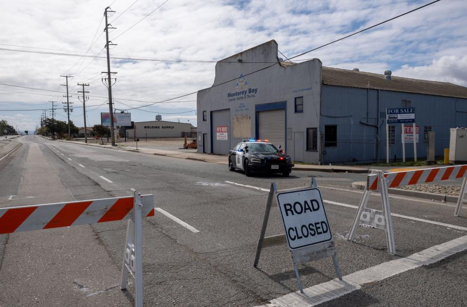 A Salinas Police Department vehicle holds traffic going into Abbott Street early morning in Salinas. The roadblock occurred after a possible ammonia spread was announced by fire officials after a Taylor Farms building was engulfed in flames late last night.