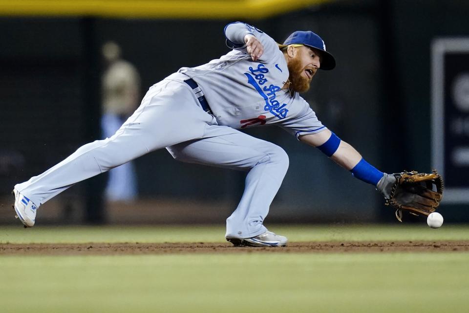 Los Angeles Dodgers third baseman Justin Turner makes a diving stop on a grounder hit by Arizona Diamondbacks' Carson Kelly before throwing to first base for the out during the eighth inning of a baseball game Saturday, Sept. 25, 2021, in Phoenix. The Diamondbacks defeated the Dodgers 7-2. (AP Photo/Ross D. Franklin)