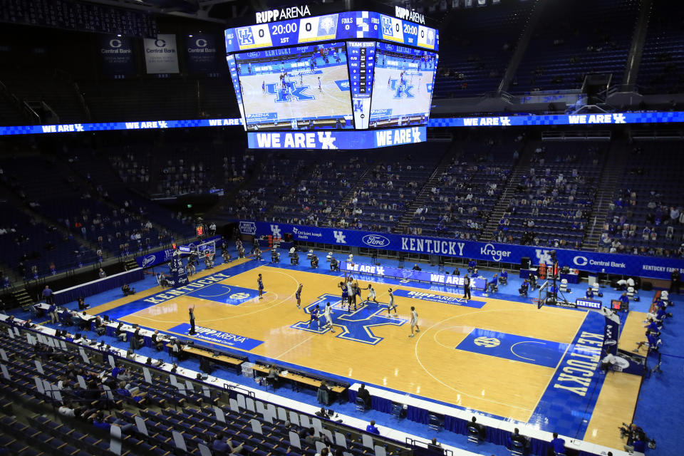 FILE - Morehead State and Kentucky players jump for the opening tip in front of a socially distanced crowd mixed with cardboard cutouts, during an NCAA college basketball game at Rupp Arena in Lexington, Ky., Wednesday, Nov. 25, 2020. (AP Photo/James Crisp, File)