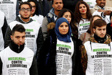 People wear T-shirts that reads: ''Muslims against Terrorism'' as they gather at The Wall for Peace (Le Mur Pour La Paix) in Paris, France November 13, 2017 as part of ceremonies held for the victims of the 2015 Paris attacks which targeted the Bataclan concert hall as well as a series of bars and killed 130 people. REUTERS/Gonzalo Fuentes