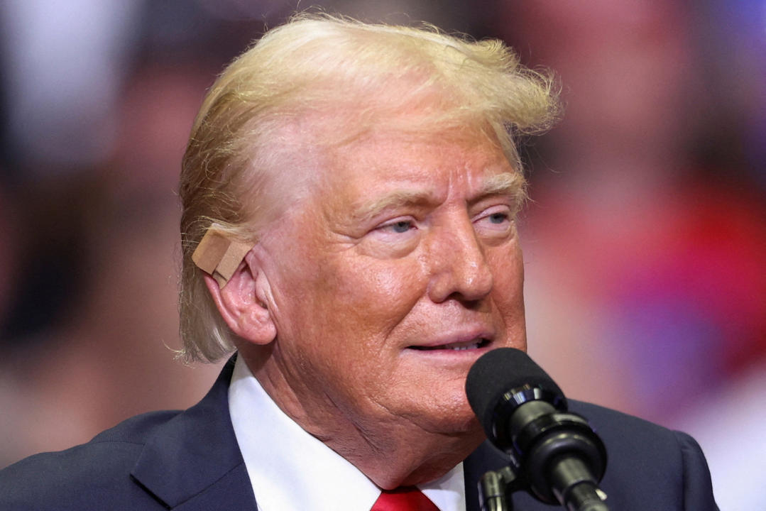 Republican presidential nominee and former U.S. President Donald Trump wears a flesh-colored bandage on his ear as he holds a campaign rally for the first time with his running mate, Republican vice presidential nominee U.S. Senator J.D. Vance (R-OH) in Grand Rapids, Michigan, U.S. July 20, 2024. REUTERS/Tom Brenner