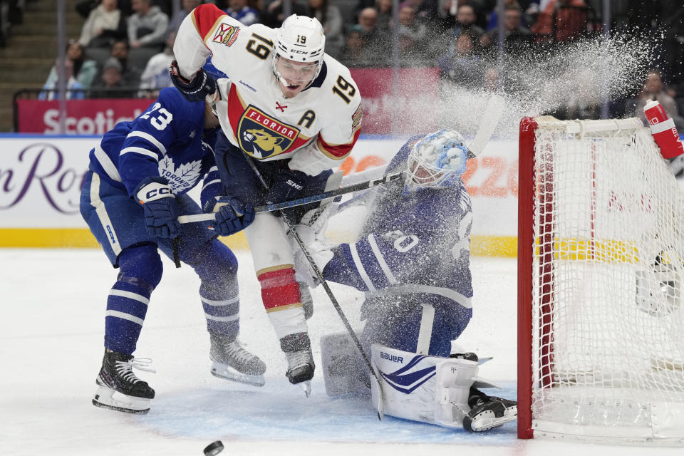 lorida Panthers left wing Matthew Tkachuk (19) crashes into Toronto Maple Leafs goaltender Joseph Woll as Leafs' Matthew Knies defends during the third period of an NHL hockey game in Toronto on Tuesday, Nov. 28, 2023. (Frank Gunn/The Canadian Press via AP)