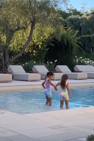 <p>Khloe Kardashian/Instagram</p> True enters the pool hand-in-hand with what appears to be her cousin Dream, 7.