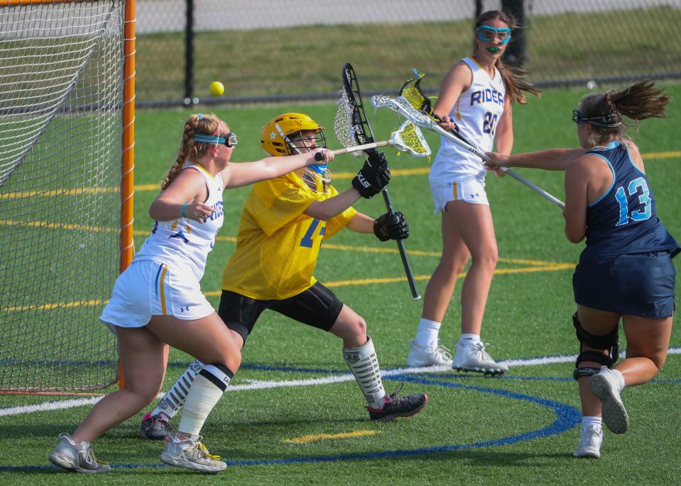 Cape Henlopen's Carrie Clausius scores past Caesar Rodney defender Sydney Milan (left) and goalie Melissa Dolt in the first half of Cape Henlopen's 17-6 win at Caesar Rodney, Wednesday, April 26, 2023. Caesar Rodney's Thalia Brown works at top.