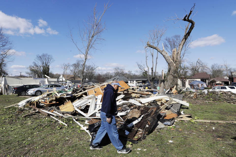 Ron Thompson Jr. walks by a pile of debris on his family's property Friday, March 6, 2020, in Nashville, Tenn. Residents and businesses face a huge cleanup effort after tornadoes hit the state Tuesday. (AP Photo/Mark Humphrey)