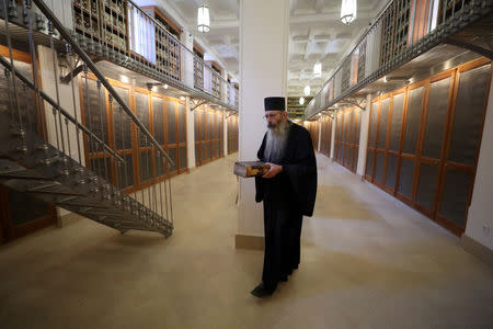 Librarian, Father Justin of Sinai, holds a manuscript as he walks inside the library of St. Catherine's Monastery in South Sinai, Egypt, March 6, 2019. REUTERS/Mohamed Abd El Ghany