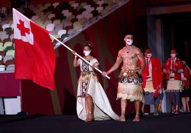Flag bearers Malia Paseka and Pita Taufatofua of Team Tonga lead their team out during the Opening Ceremony of the Tokyo 2020 Olympic Games. (Photo: Hannah McKay - Pool via Getty Images)