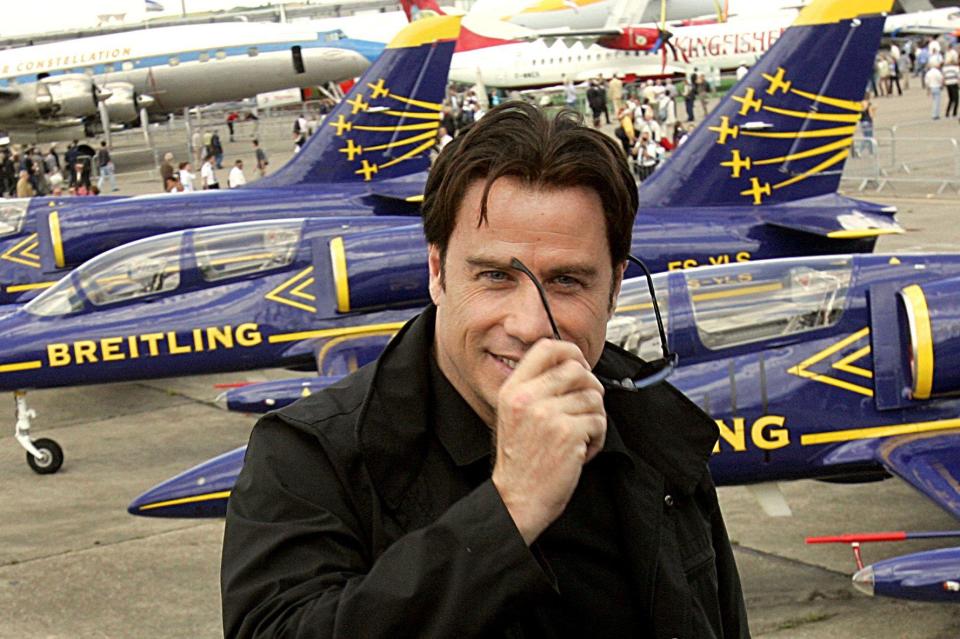 U.S. movie star John Travolta, removes his sunglasses as he faces photographers, during his visit of the 47th Paris Air Show in Le Bourget, north of Paris, Thursday June 21, 2007.(AP Photo/Christophe Ena)