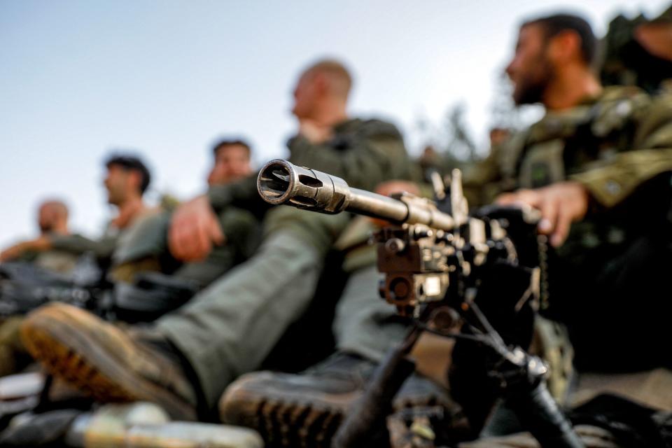 TOPSHOT - An Israeli army soldier sits by a machine gun deployed on a tripod at a position in the upper Galilee region of northern Israel near the border with Lebanon on October 28, 2023 amid increasing cross-border tensions between Hezbollah and Israel as fighting continues in the south with Hamas militants in the Gaza Strip. Since Palestinian militant group Hamas carried out an unprecedented attack on Israel from the Gaza Strip on October 7, Lebanon's southern border has seen tit-for-tat exchanges between Israel and the Iran-backed Hezbollah, a Hamas ally. (Photo by Jalaa MAREY / AFP) (Photo by JALAA MAREY/AFP via Getty Images)