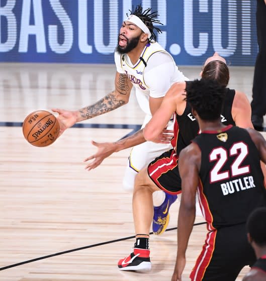 Lakers forward Anthony Davis commits a foul by charging into Heat center Kelly Olynyk during Game 3 on Sunday night.