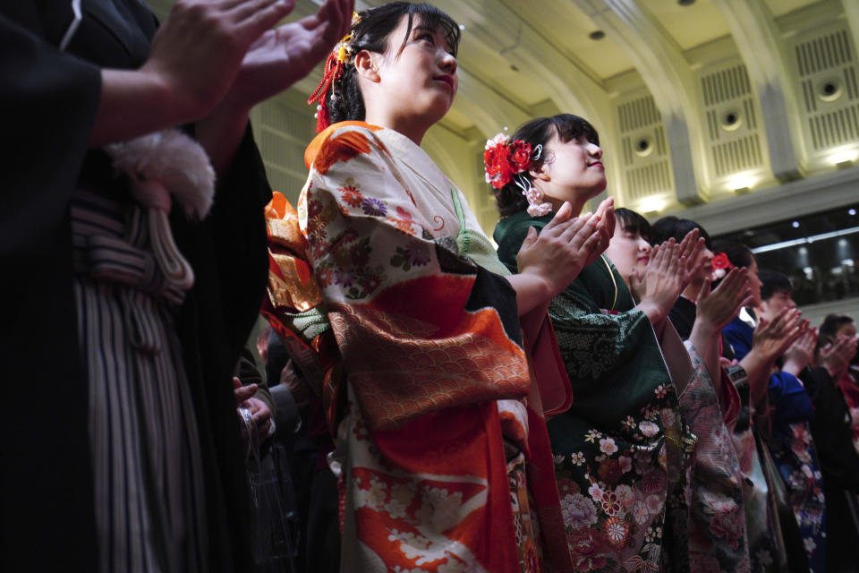 Kimono-clad employees of the Tokyo Stock Exchange and models clap during a ceremony marking the start of this year's trading in Tokyo Monday, Jan. 6, 2020, in Tokyo. (AP Photo/Eugene Hoshiko)