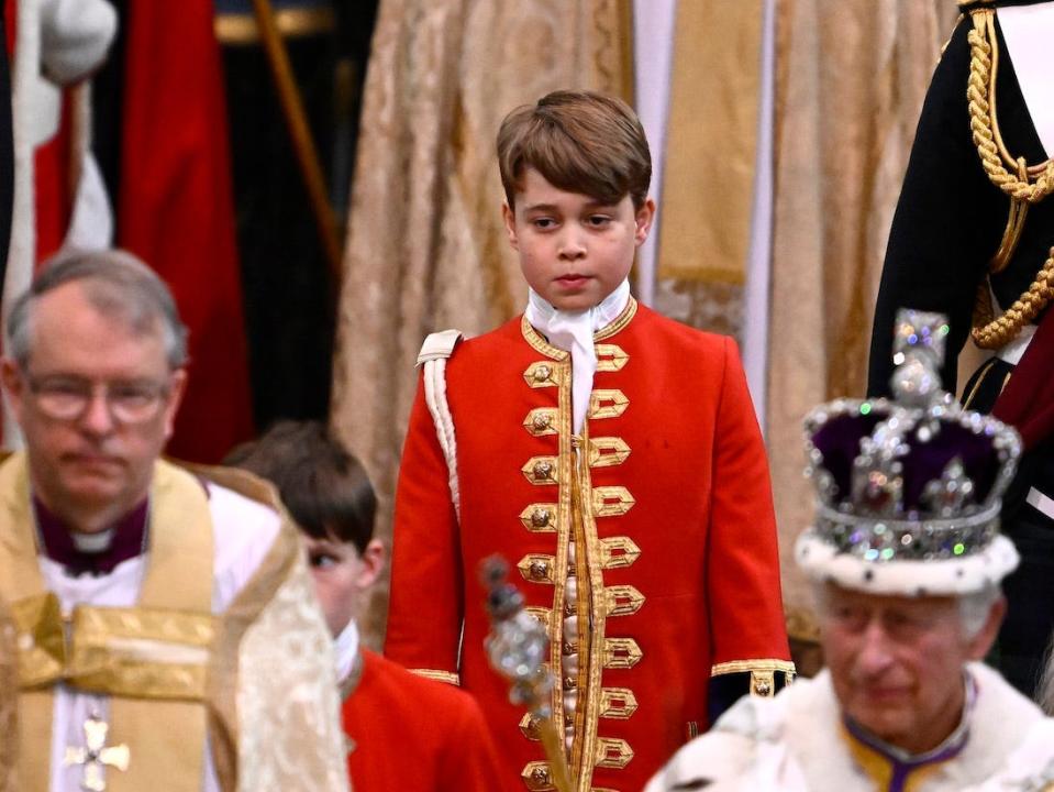 Prince George of Wales pictured carrying the train of King Charles' coronation robes as they depart Westminster Abbey on May 6, 2023.