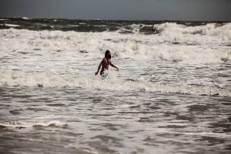 A man swims in water that is now considered to be dangerous due to high tides from Hurricane Dorian in St. Augustine