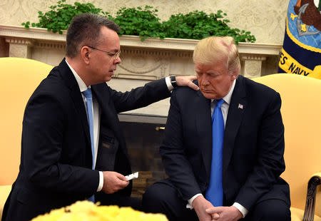 President Donald Trump closes his eyes in prayer along with Pastor Andrew Brunson, after his release from two years of Turkish detention, in the Oval Office of the White House, Washington, U.S., October 13, 2018. REUTERS/Mike Theiler