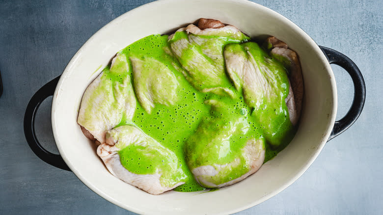 Chicken in green herb marinade in casserole dish