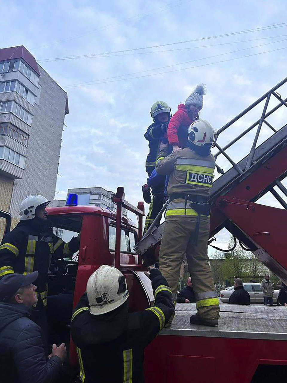 In this image provided by the State Emergency Service of Ukraine, firefighters evacuate a girl from a destroyed apartment building after a Russian attack in the town of Uman, around 215 kilometers (134 miles) south of Kyiv, Ukraine, Friday, April 28, 2023. (State Emergency Service of Ukraine via AP)