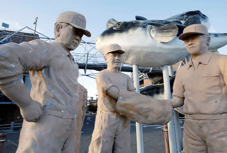 Statues of pufferfish auctioneers featuring their auction style that uses a bag to hide their secret hand signs are displayed in front of of Karato fish market in Shimonoseki, southern Japan November 13, 2018. REUTERS/Mari Saito