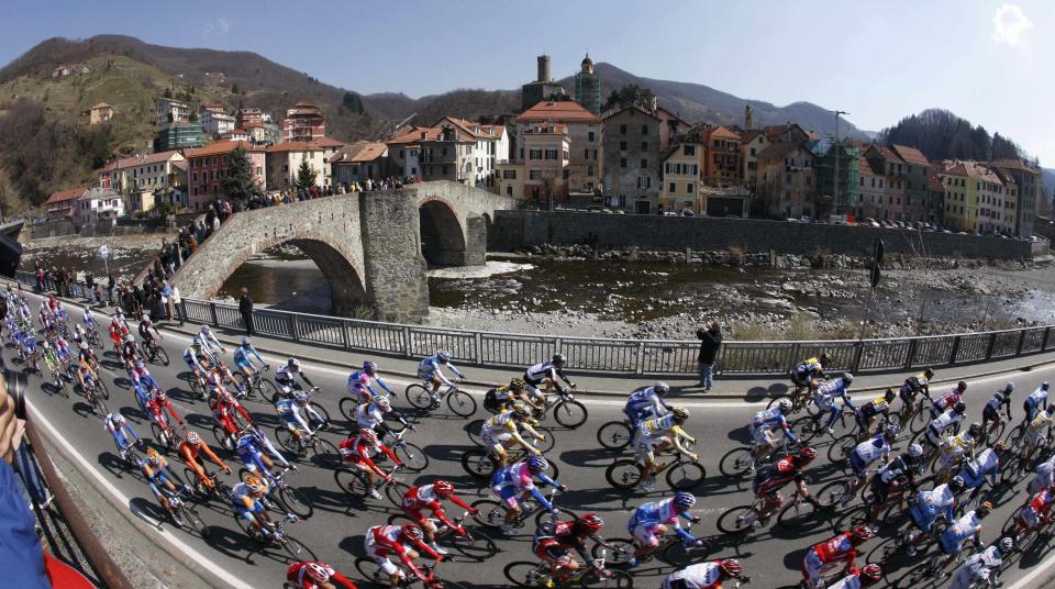 FILE - In this Saturday, March 21, 2009 file photo, the pack pedals by the town of Campo Ligure during the Milan-San Remo cycling classic in Italy. The impact of the Covid-19 virus on cycling has been escalating as Australian team Mitchelton-Scott decided to withdraw from racing until March 22. (AP Photo/Alessandro Trovati, File)