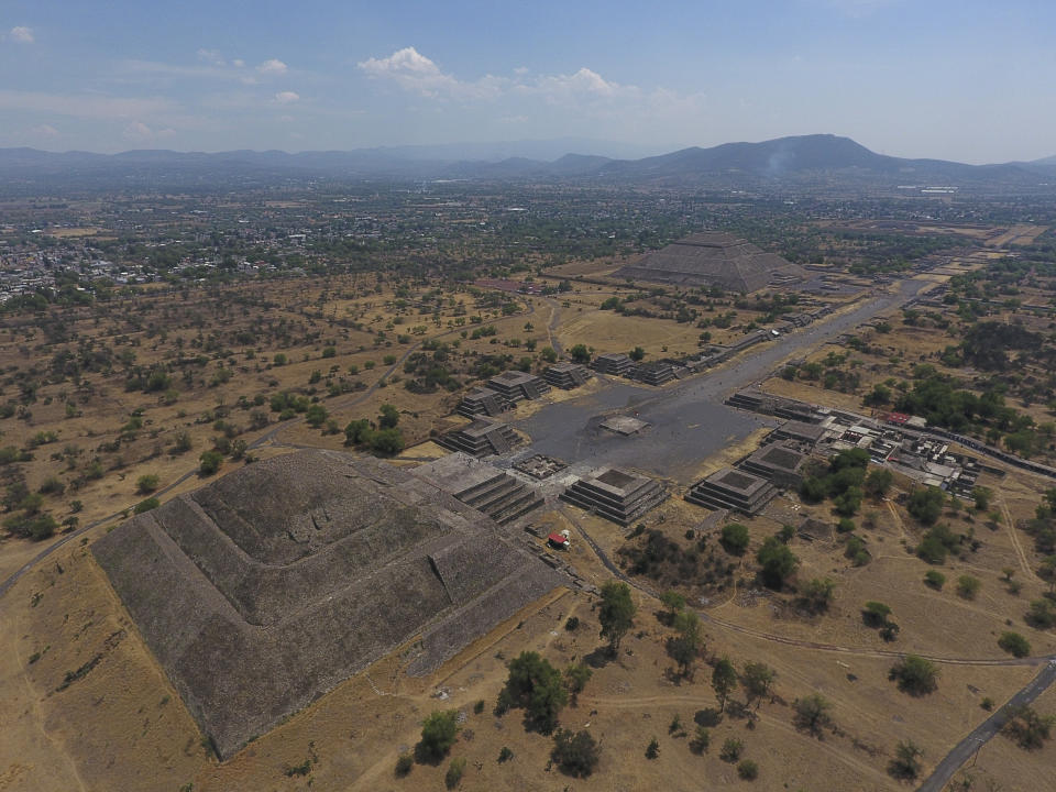 FILE - In this March 19, 2020 file photo, the Pyramid of the Moon, left, and the Pyramid of the Sun, back right, are seen along with smaller structures lining the Avenue of the Dead, in Teotihuacan, Mexico. The Mexican government said Tuesday, May 25, 2021, that a private building project is destroying part of the outskirts of the pre-Hispanic ruin site of Teotihuacan, just north of Mexico City. (AP Photo/Rebecca Blackwell, File)