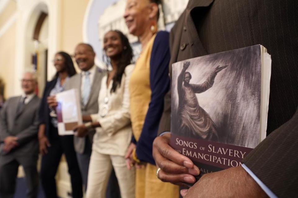 Dr. Amos C. Brown, Jr., vice chair for the California Reparations Task Force, right holds a copy of the book Songs of Slavery and Emancipation, as he and other members of the task force pose for photos at the Capitol in Sacramento, Calif., Thursday, June 16, 2022. California Gov. Gavin Newsom vetoed a bill Thursday, Sept. 29, 2022, that would have granted more time for the reparations task force to complete it’s work at the request of Secretary of State Shirley Weber, who introduced the original reparation task force bill while a member of the state Assembly. The Coalition for a Just and Equitable California and other organizations sent a letter to Newsom saying the extension would send a demoralizing message to African Americans waiting for restitution.. (AP Photo/Rich Pedroncelli, File)